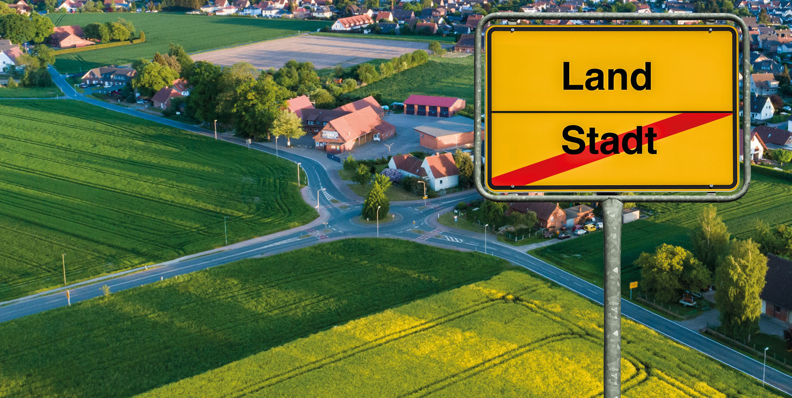 Feld und Orstschild mit Beschriftung Land und Stadt
